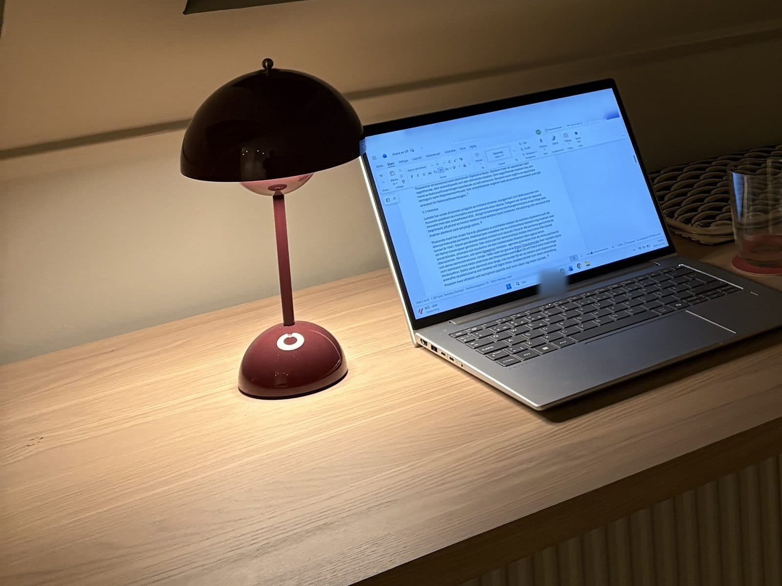 Laptop open under a desk lamp at night