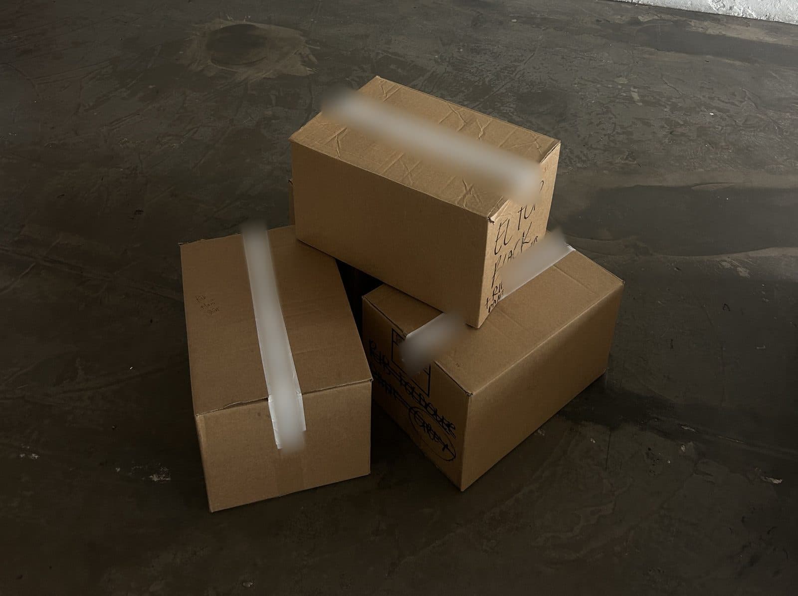 Three taped cartons on a concrete floor