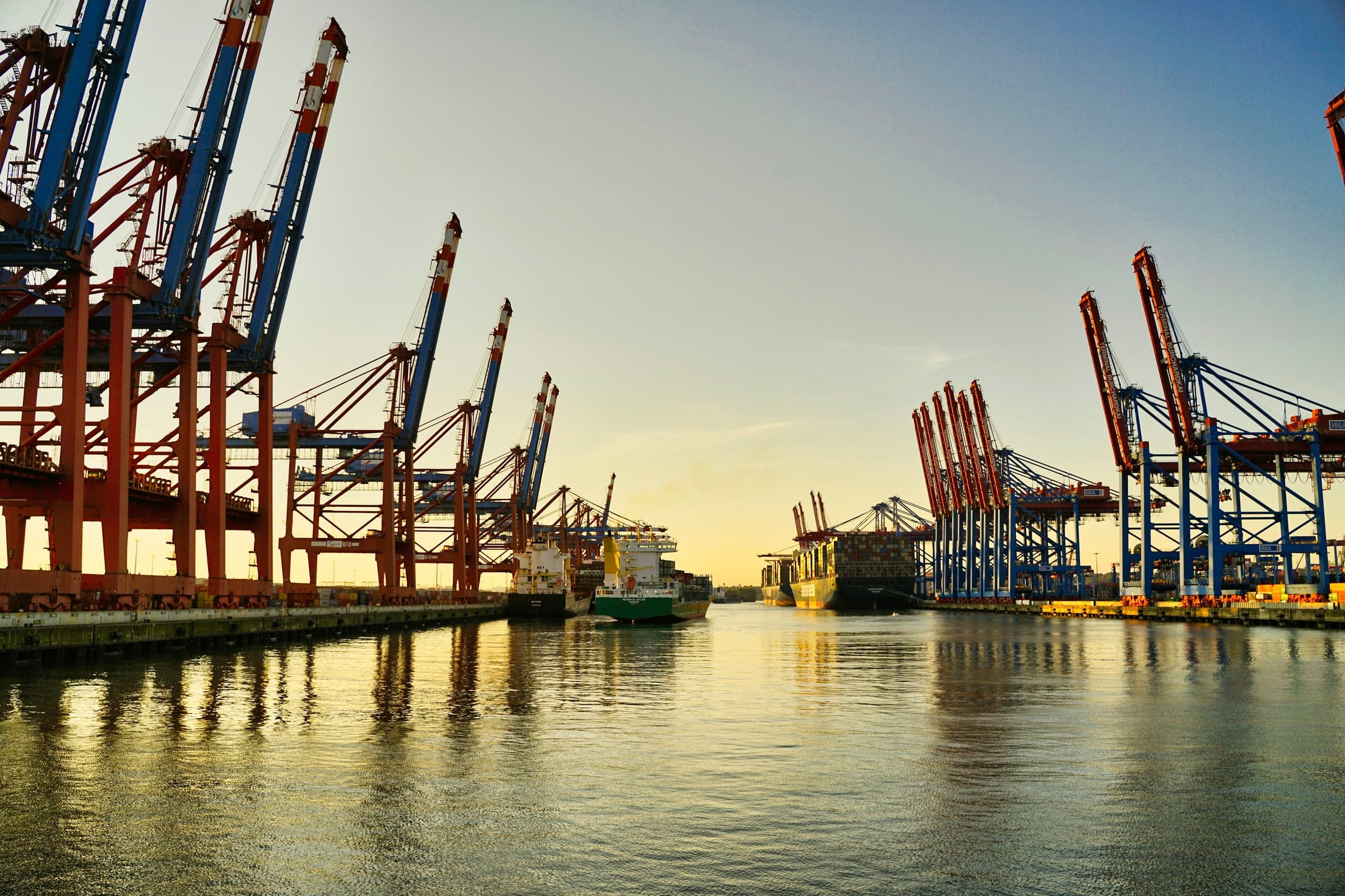 Container cranes along a harbour channel at dusk